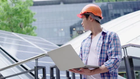 Engineer or construction worker Asian man is using laptop to check solar cell Stock Footage 142702795
