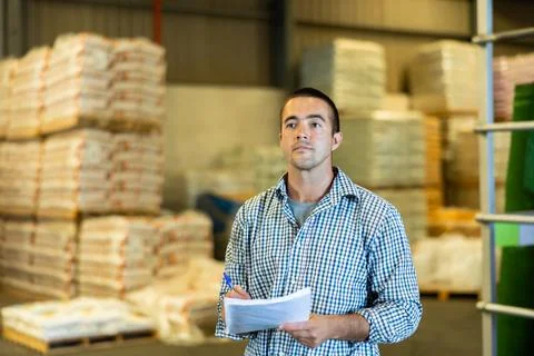 Engineer or foreman holding documents and checking inventory or job details 写真素材