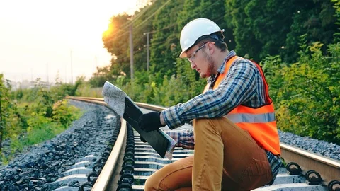 The engineer or inspector checking drawing or route map of railway for find some Stockbeeldmateriaal 96015713