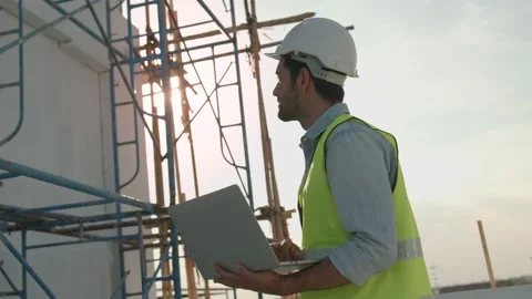 Engineer or inspector wearing white helmet and holding laptop Stock Footage 146027315