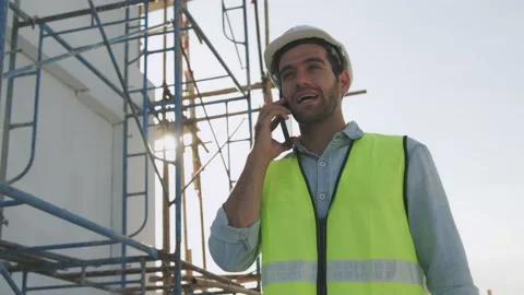 Engineer or inspector wearing white helmet talking on phone Stock Footage 146027447