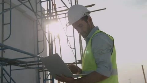 Engineer or inspector wearing white helmet and holding laptop to check Stock Footage 146681029