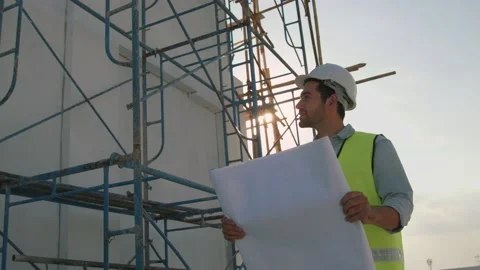Engineer or inspector wearing white helmet and holding blueprint Stock Footage 147655719
