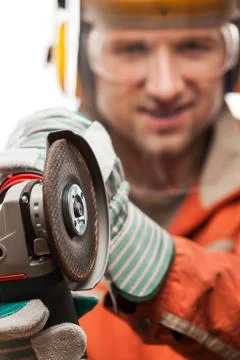 Engineer or manual worker man in safety hardhat helmet holding angle grinder  Stock Photos