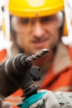 Engineer or manual worker man in safety hardhat helmet holding hammer drill t Stock Photos