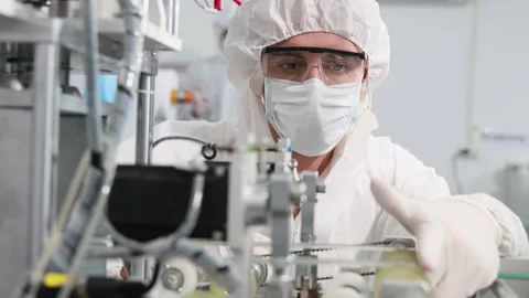 Engineer or technician in protective suite working on medical face mask machine  Stock Footage 158468745