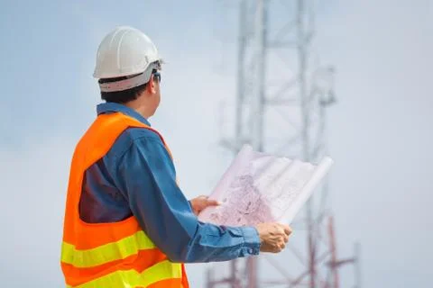 Engineer or Technocian hold plan and look at Telecommunication tower base Stock Photos