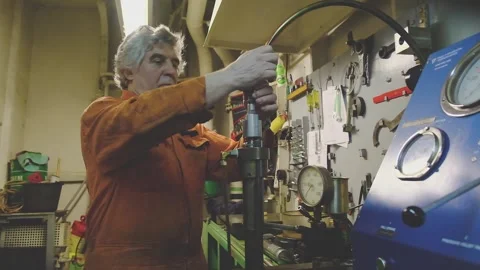 Engineer in overall repairs equipment in mechanical workshop Video stock 133036748