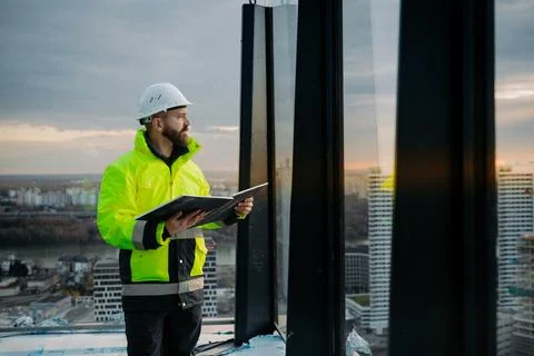 Engineer overseeing city construction project, reading documentation. Stock Photos