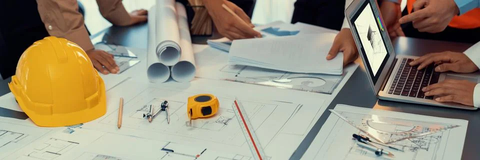 Engineer partner drawing and working on blueprint design together. Insight Stock Photos