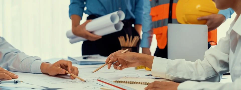 Engineer partner drawing and working on blueprint design together. Insight Stock Photos