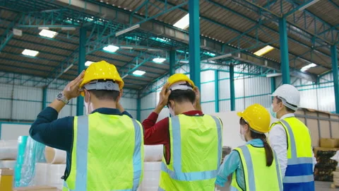 Engineer people are putting a protective helmet on  head in warehouse Stock Footage 158174817