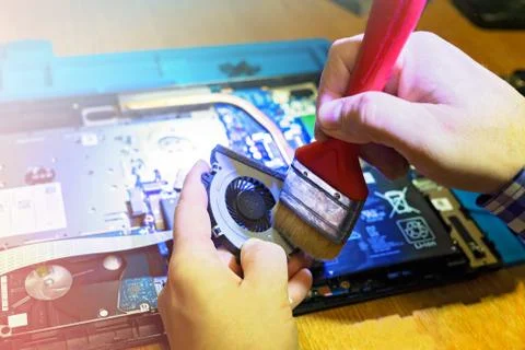 Engineer performs mechanical cleaning of laptop cooler 写真素材