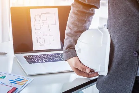 Engineer planing or worker hold in hand white helmet in the office Stock Photos