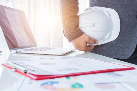 Engineer planing or worker hold in hand white helmet in the office Stock Photos