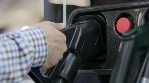 Engineer plugging charging gun into electric vehicle socket. Media Stock Footage 315266271