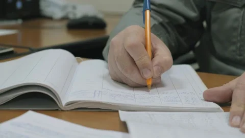 An engineer prepares documents at a table in an office. An office worker works Stock Footage 150757078