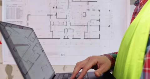 Engineer presses keys on laptop entering data about flat layout 動画素材 309927206