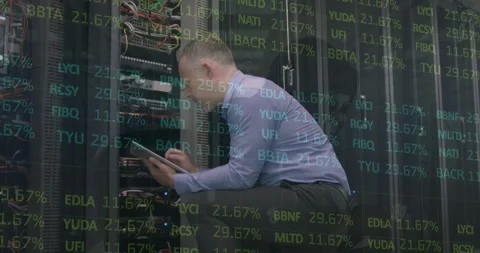 Engineer processes stock data on tablet in server room, highlighting finance Stock Footage 330593271