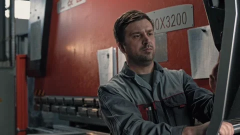 Engineer professional in uniform works at the screen of a large hydraulic press Stock-Footage 265508519