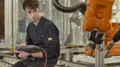 Engineer programming  automatic industrial robot by teach pendant in automotive 動画素材 124610661