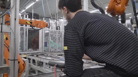 Engineer programming automatic industrial robot in automotive industrial factory 動画素材 124611658