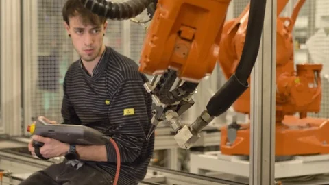 Engineer programming / setting up automatic industrial robotic arm / center 動画素材 124610816