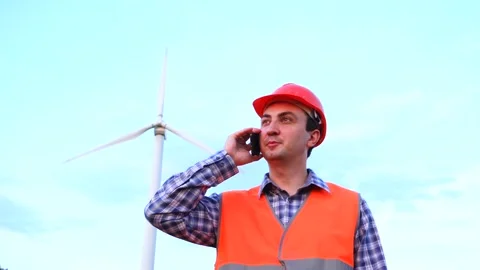 Engineer projects the work near the wind turbine. Makes a phone call Stock Footage 137046038