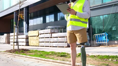 Engineer with prosthetic leg working on construction site Stock Footage 260558726