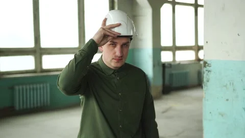 An engineer puts a safety helmet on his head on site. Looks into the camera Stock Footage 152679673