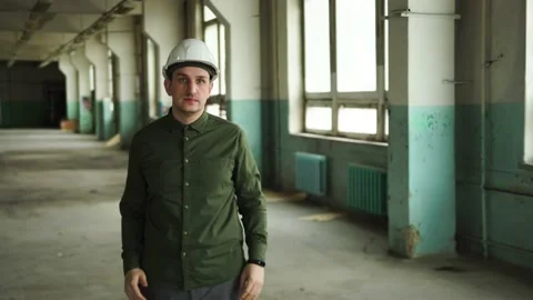 An engineer puts a safety helmet on his head on site. Looks into the camera Stock Footage 152679793