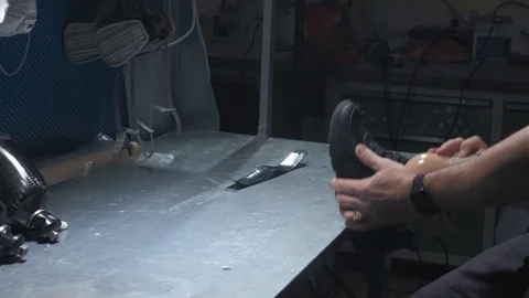 An engineer puts on sneakers on a prosthetic leg. Inserts the prosthesis into Stock Footage 120157200