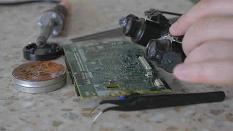 Engineer puts on the table magnifying lens in workshop of electronics, gadgets Stock Footage 86673093