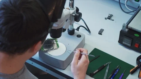 An engineer puts the wireless access module Wi-Fi on the site with a microscope 스톡 동영상 105971391