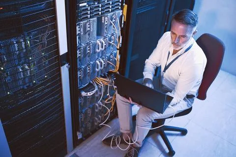 Engineer, reading and man with laptop in server room, online and troubleshooting Stock Photos