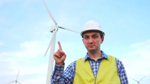 Engineer rejecting, waving finger in front of wind turbines ecological energy Stock Footage 137967728