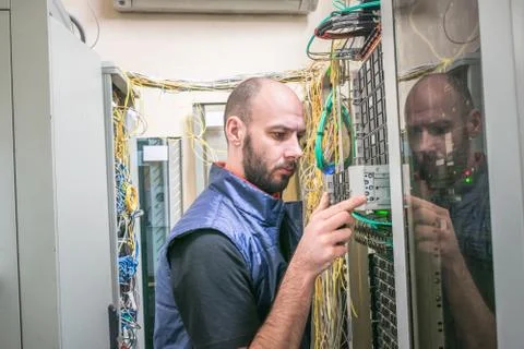 The engineer removes computer equipment from the server cabinet. Maintenance  库存照片