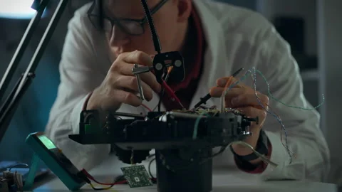 Engineer repairing a robotic device in a modern laboratory during the daytim Stock Footage 331296822