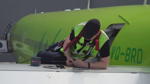 Engineer repairing wing of a passenger plane. Repair of the tail of the aircraft Stock Footage 84436141