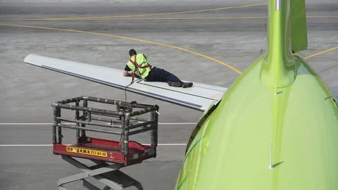Engineer repairing wing of a passenger plane. Repair of the tail of the aircraft Stock Footage 84452082