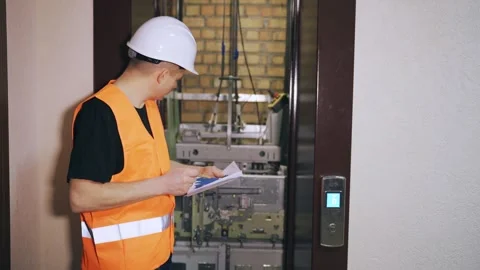 Engineer repairman construction worker checks the operation of the elevator Stock Footage 262802369