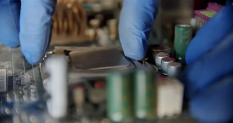 Engineer repairman holding chip processor CPU in hands to insert into the socket Stock Footage 151069323