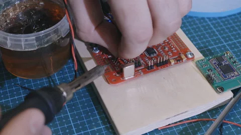 Engineer repairs circuit chipboard by soldering in workshop Stock Footage 194522975