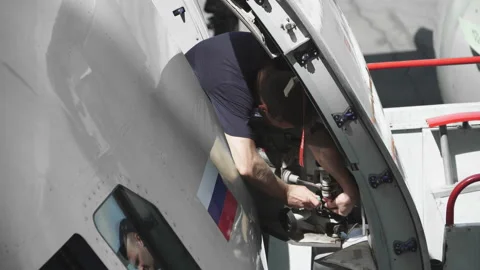 Engineer repairs the door of a passenger plane. The plane in the door repair. 4k Stock Footage 107284961
