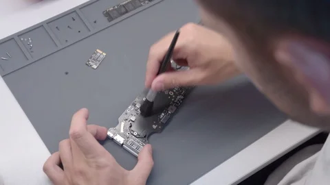 The engineer repairs water damaged laptop. The engineer extract matherboard of Stock Footage 91334864