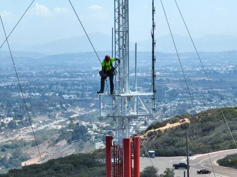 Engineer with safety equipment on high tower for working telecom communication Stock Photos