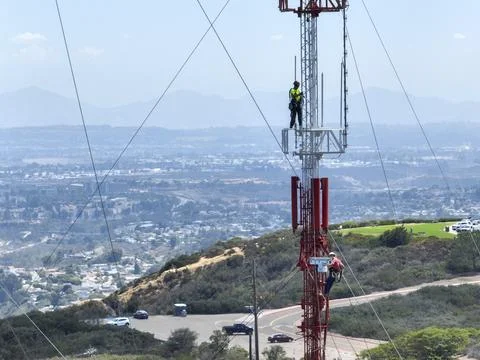 Engineer with safety equipment on high tower for working telecom communication Stock Photos