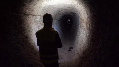 Engineer in Safety Gear Inspecting Dark Underground Mine Shaft Stock Footage 334939613