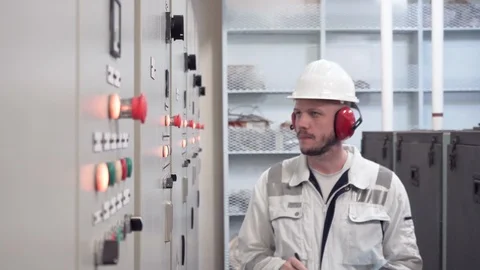 Engineer in safety helmet and white workwear inspects a parameters of indicators Stock Footage 118073394
