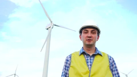 Engineer saying in front of wind turbines ecological energy industry power Stock Footage 137969033